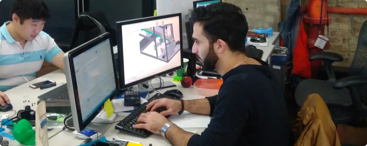 LabsCubed engineers collaborating on CAD design for tensile testing equipment development.