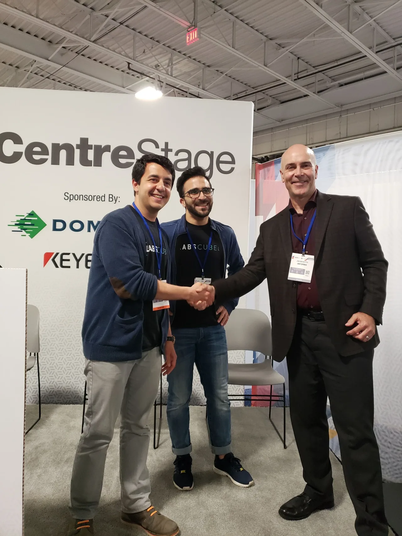 LabsCubed co-founders shaking hands on the CentreStage at the PLAST-EX and Advanced Design & Manufacturing Expo.