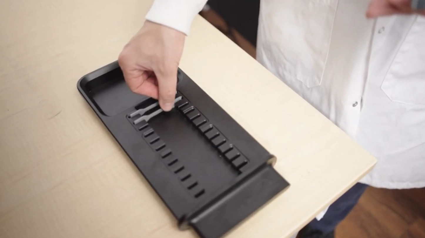 Loading rubber samples into the CubeOne tray for automated tensile testing.
